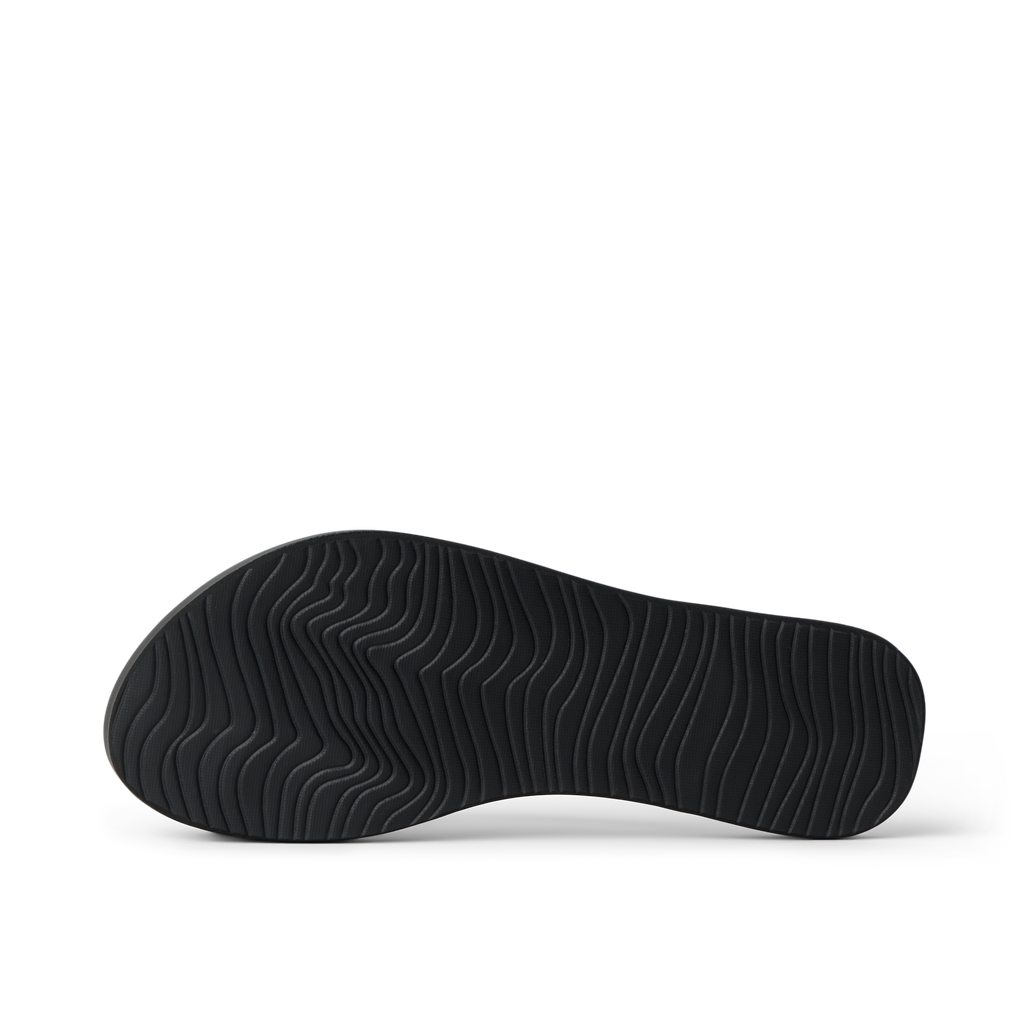 Bottom sole of Cushion Slim black women's footwear showing textured water-friendly rubber grip for beach comfort and durability