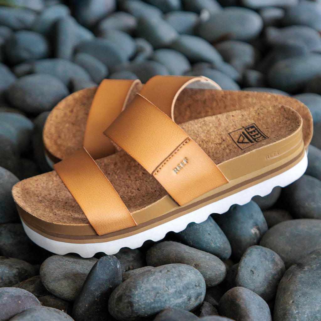 Pair of Cushion Vista Hi sandals faced left, close-up of upper straps and cushioned footbed on smooth stones.
