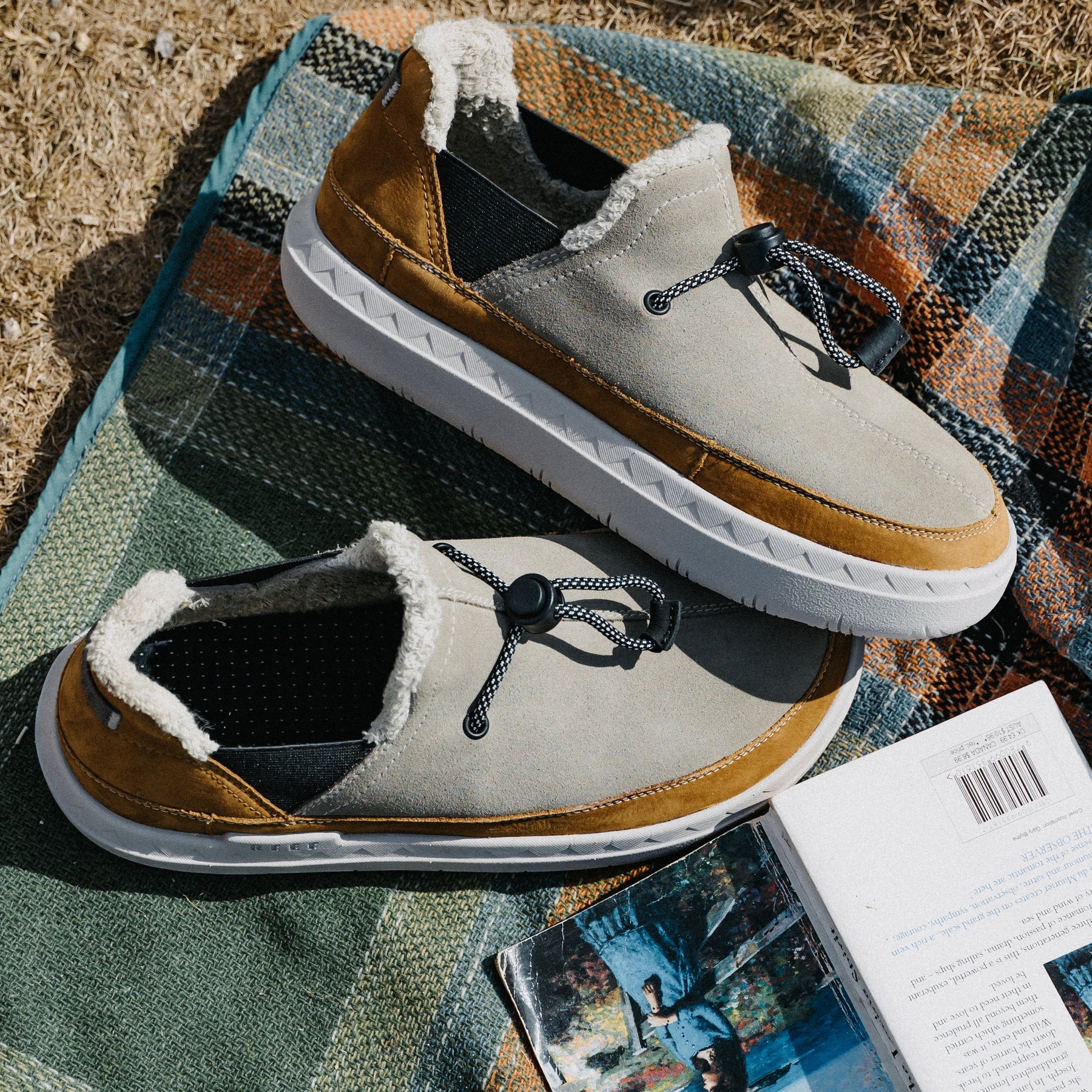 Rambler suede shoes facing right on a blanket, showing cozy terrycloth lining and cushioned white soles