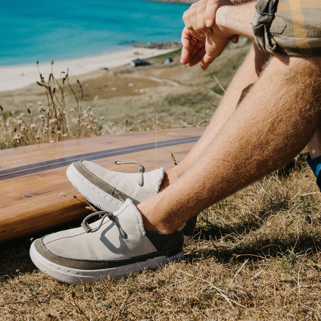 Rambler gray suede shoes facing left outdoors near the beach