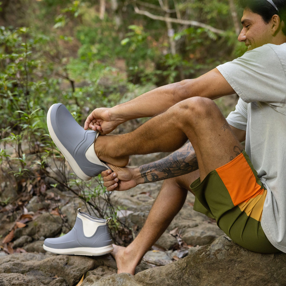 Man wearing grey Scallywag slip-on shoes facing left, showing side with lightweight, water-friendly design.