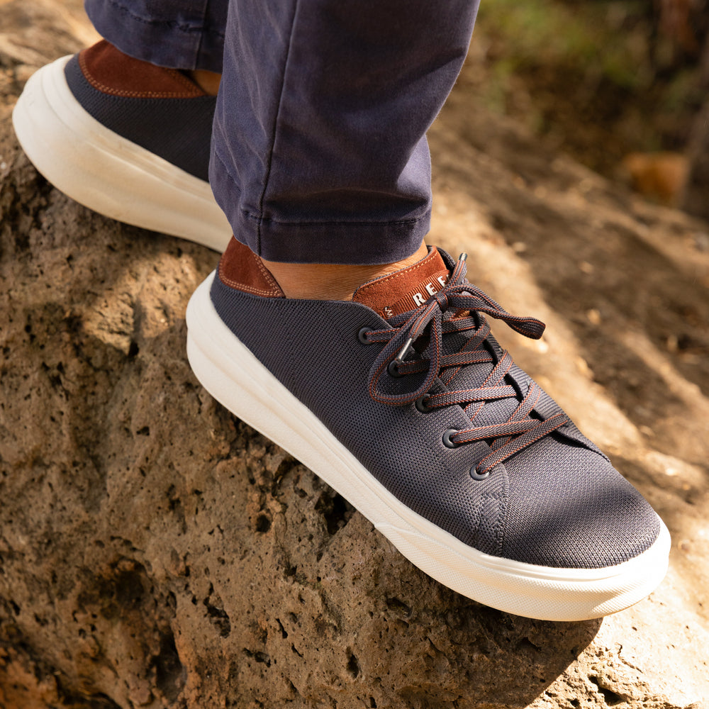 Atlantic men's sneaker facing right on rocky surface, navy and cappuccino with cushioned sole designed for beach comfort.