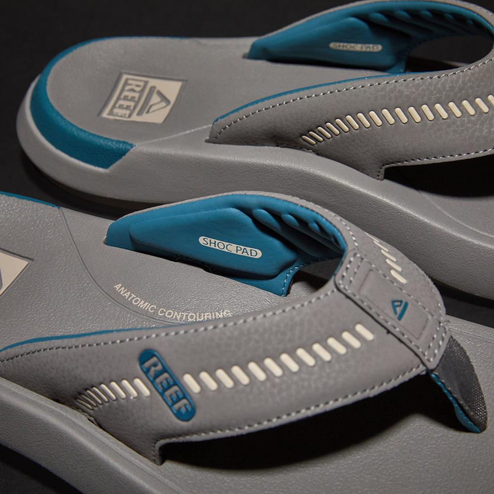 Close-up of the top and side of the gray and blue Cruiser men’s flip flops facing right, highlighting comfort features.