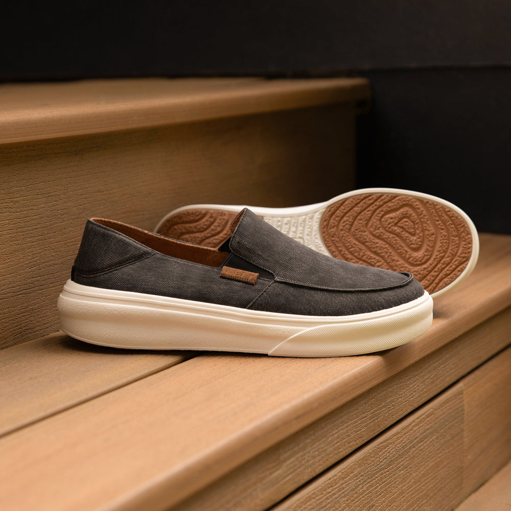 Pacific men's black slip-on shoes facing left with close-up of side and textured sole, featuring comfort and durable design.