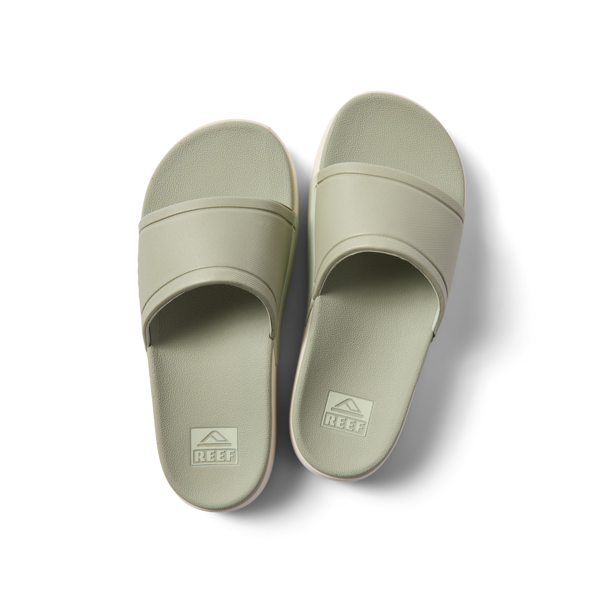 Pair of sage green Sydnee Cutback Low slides facing upward, showcasing comfort-focused footbed and water-friendly design.
