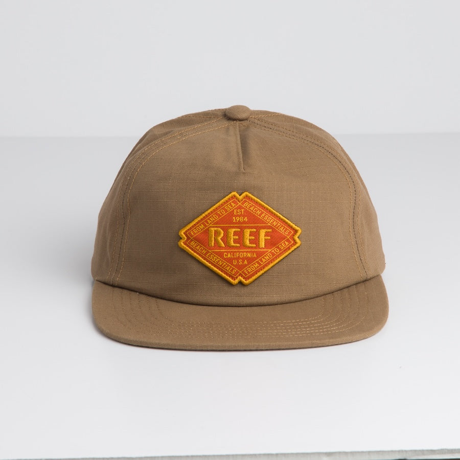 Front view of Stafford Ripstop Hat in brown with yellow REEF embroidered patch, surf-inspired comfort design.