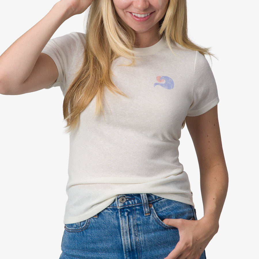 Woman wearing a white Surf Club Fitted Tee with a small graphic, shown from waist to shoulders, front view.