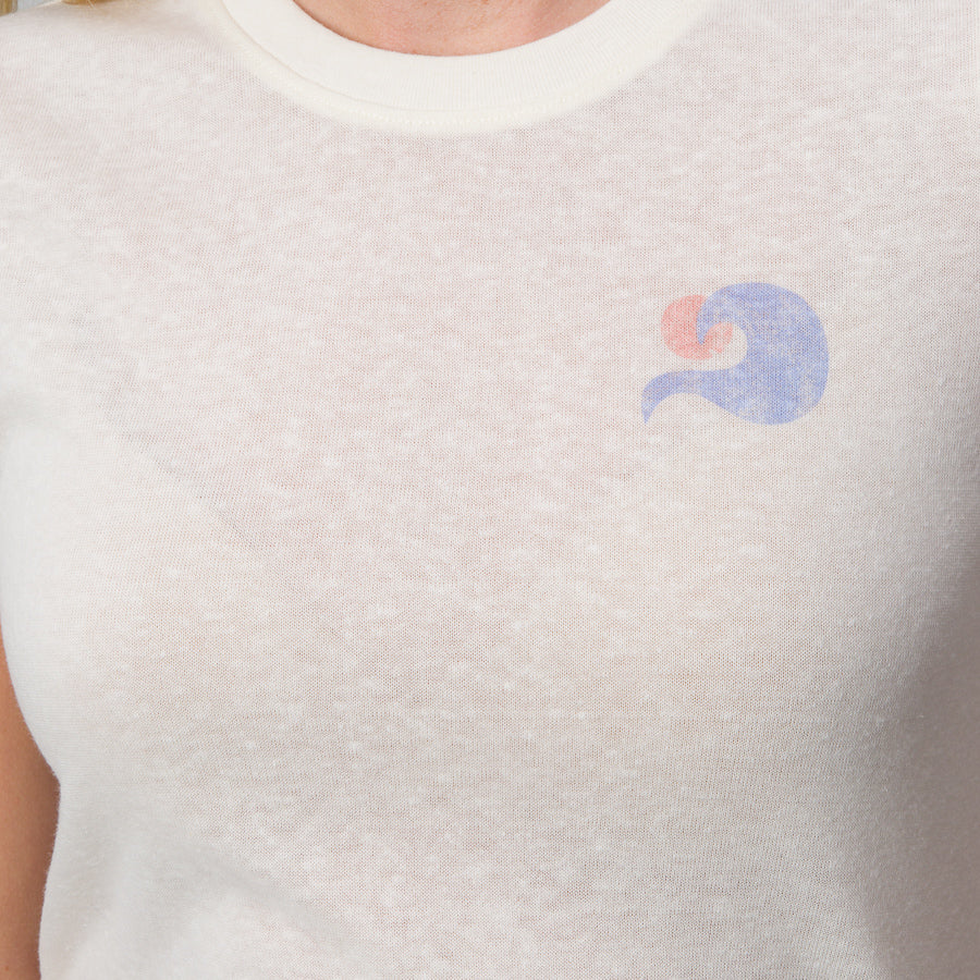 Close-up of the chest area of a woman’s Surf Club Fitted Tee in marshmallow color with small wave logo on left side.