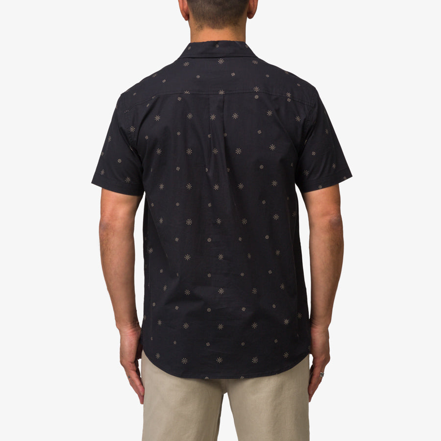 Man wearing the back view of the Topaz Shirt in black with subtle pattern, designed for beach comfort and style.