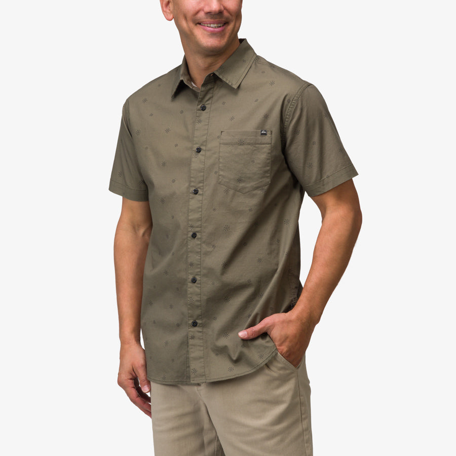 Man wearing olive green Topaz Shirt facing forward with hand in pocket, surf-inspired comfort apparel for men.