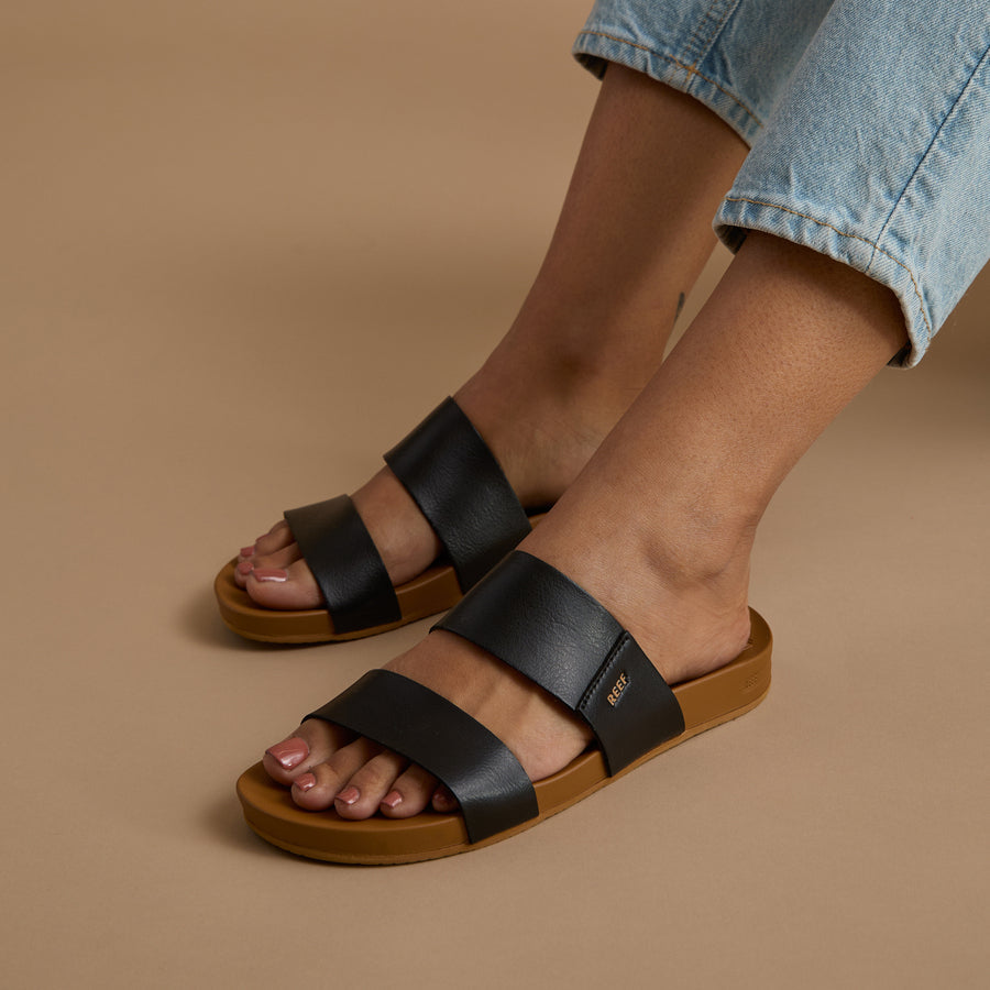Cushion Vista sandals facing left, close-up of the top and side showing black straps and cushioned sole for comfort.