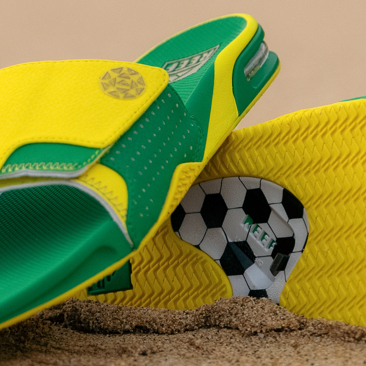 Fanning Slide facing left showing green and yellow water-friendly men's slide with cushioned footbed and soccer ball bottle opener sole detail.