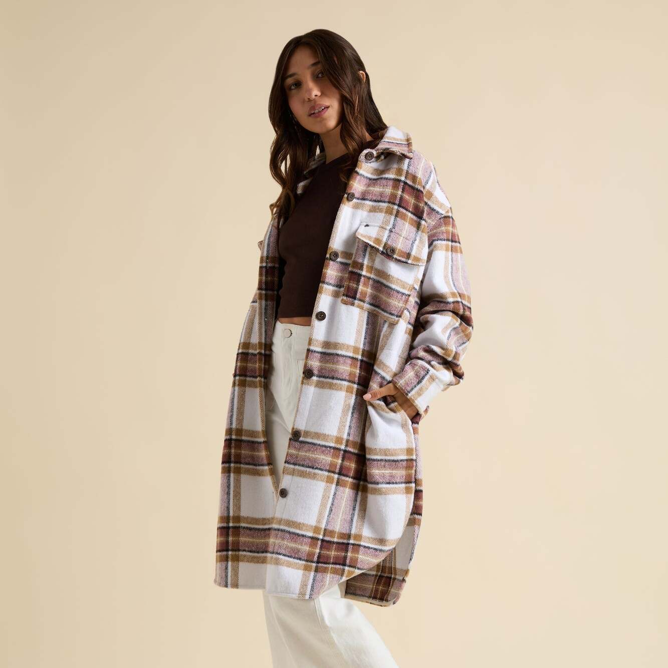 Woman wearing a Victorian Shacket in neutral plaid, front view, showcasing comfort and beach-inspired style apparel.